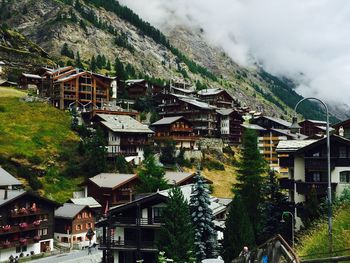 Houses on mountain against sky