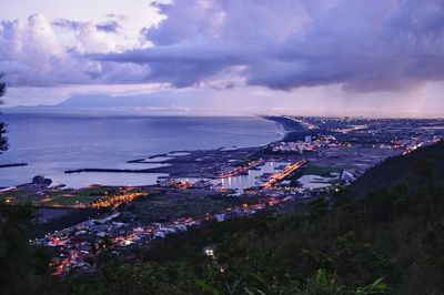 High angle view of city by sea against sky