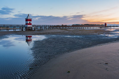 Pier over sea against sky during sunset