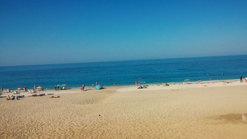 Scenic view of beach against clear blue sky