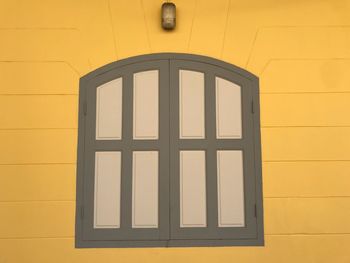 Yellow window on brick wall