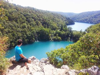 Man standing on rock by lake