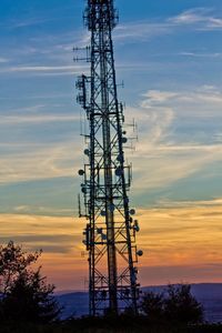 Low angle view of silhouette electricity pylon against sky during sunset