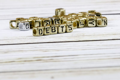 Close-up of debt text made with golden toy blocks on table