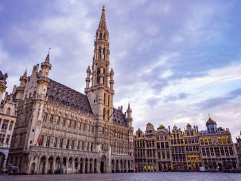 Buildings in city against cloudy sky