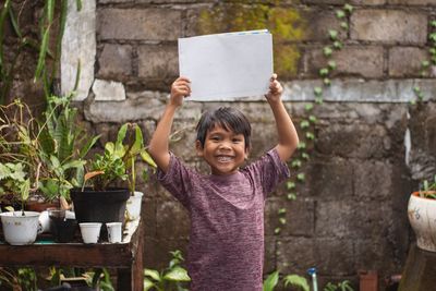 Portrait of smiling young boy showjng board sign