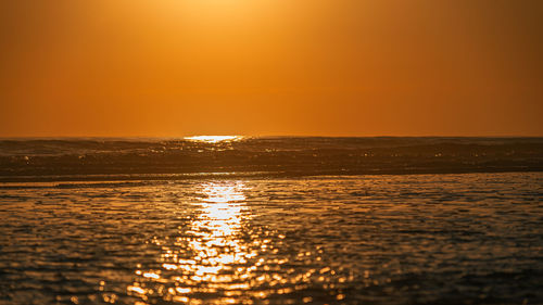 Scenic view of sea against orange sky