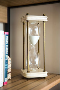 Hourglass on wooden shelf