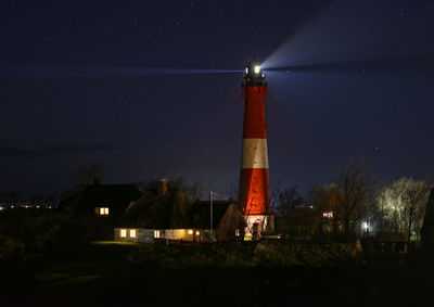 Low angle view of lighthouse against sky at night