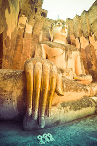 Sculpture of buddha statue against built structure