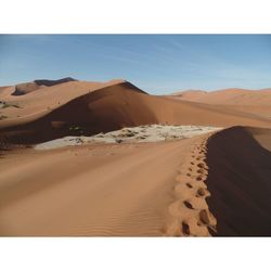 Sand dunes at namibian desert against sky