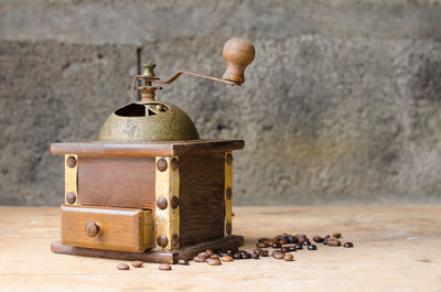 Close-up of coffee grinder on table against wall
