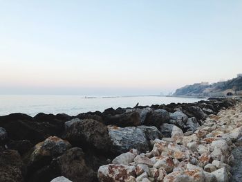 Rocks on beach against clear sky