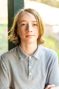 Candid portrait of teenage boy smiling with shoulder length hair