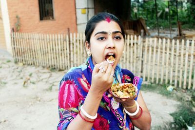 Portrait of young woman eating food