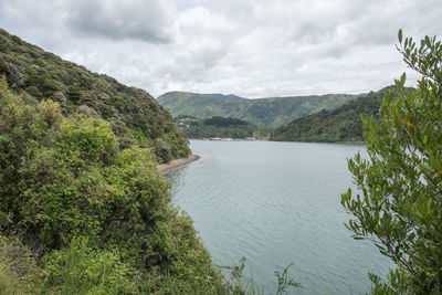 Scenic view of river amidst mountains against sky