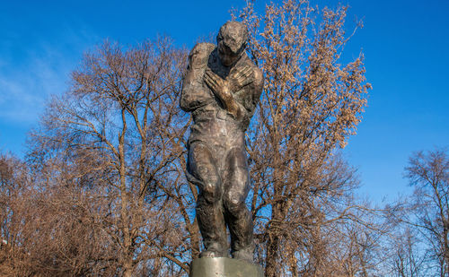 Low angle view of horse statue against trees