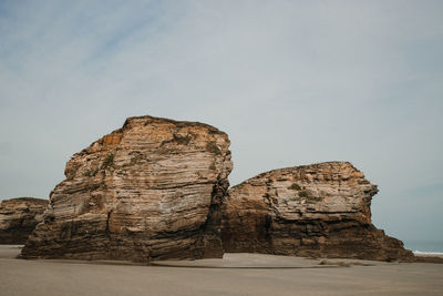 Low angle view of rock formation on sea against sky