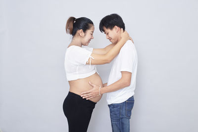 Young couple standing against white background