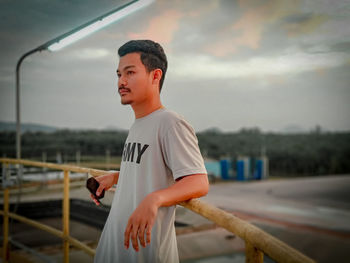 Full length of man standing by railing against sky