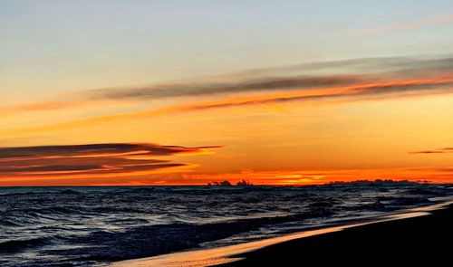 Scenic view of sea against romantic sky at sunset