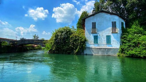 Building by river against sky