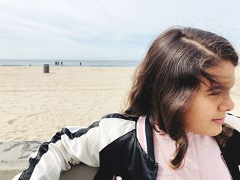 Portrait of woman on beach against sky