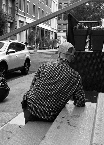 REAR VIEW OF MAN ON STREET AGAINST CITY