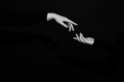 Close-up of hand over black background