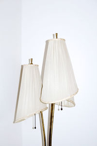 Close-up of modern floor lamps against white wall