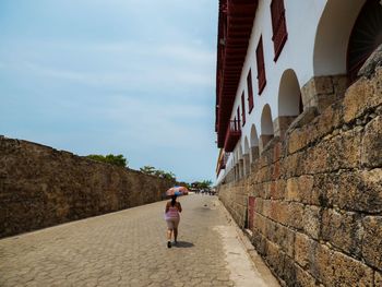 Full length of woman walking on footpath