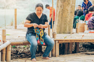 Full length of woman sitting outdoors