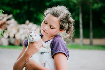 Portrait of cute girl holding baby outdoors