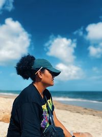 Man wearing hat on beach against sky