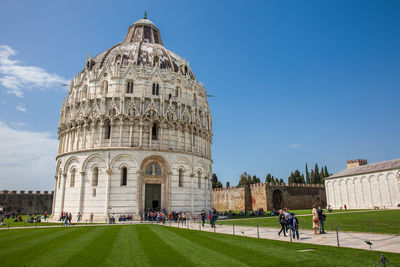 Tourists at the pisa baptistery of st. john in a beautiful early spring day