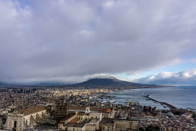 High angle view of townscape by sea against sky