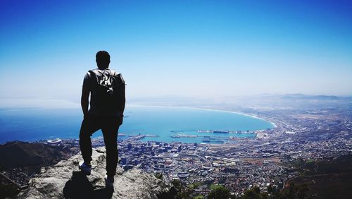 Rear view of man looking at sea against sky