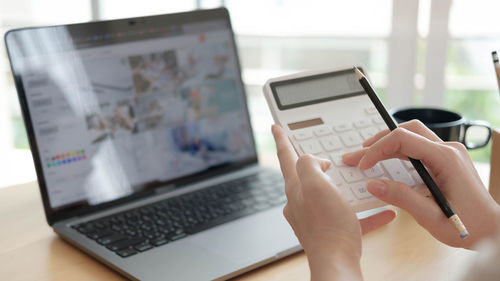 Midsection of man using laptop on table