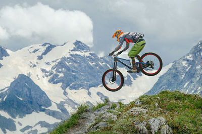 Rear view of man riding bicycle on mountain