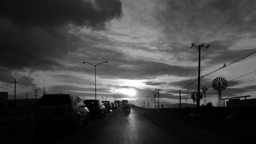 Cars on road in city against sky