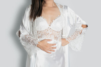 Woman holding umbrella standing against white background