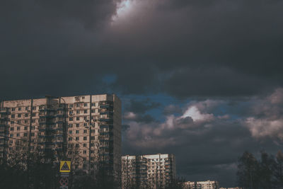 Low angle view of buildings against cloudy sky