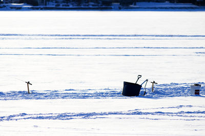 Scenic view of snow covered field by sea