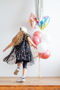 Happy girl spinning. girl with long hair sits on a chair. girl in a pink fluffy dress. 