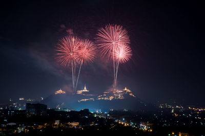 Firework display over cityscape at night