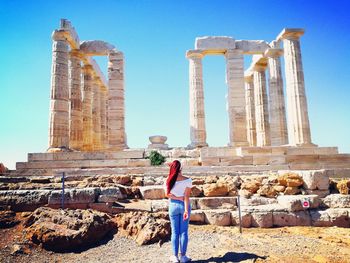 Low angle view of woman standing against built structure