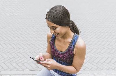 Beautiful hispanic woman using on the street