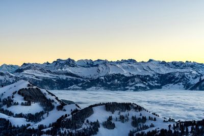 Scenic view of snowcapped mountains against clear sky during winter