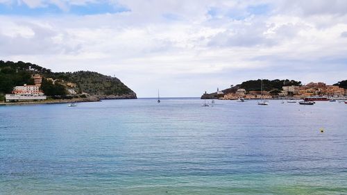 Scenic view of sea by buildings against sky