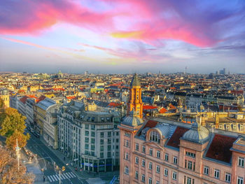 Aerial view of cityscape against cloudy sky